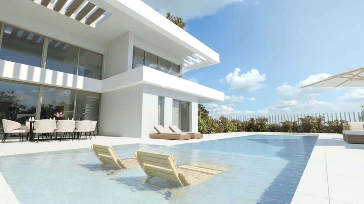 Tailor-Made Villa Manilva – Manilva - modern white exterior with infinity pool, in-pool sun loungers and outdoor dining terrace under blue skies