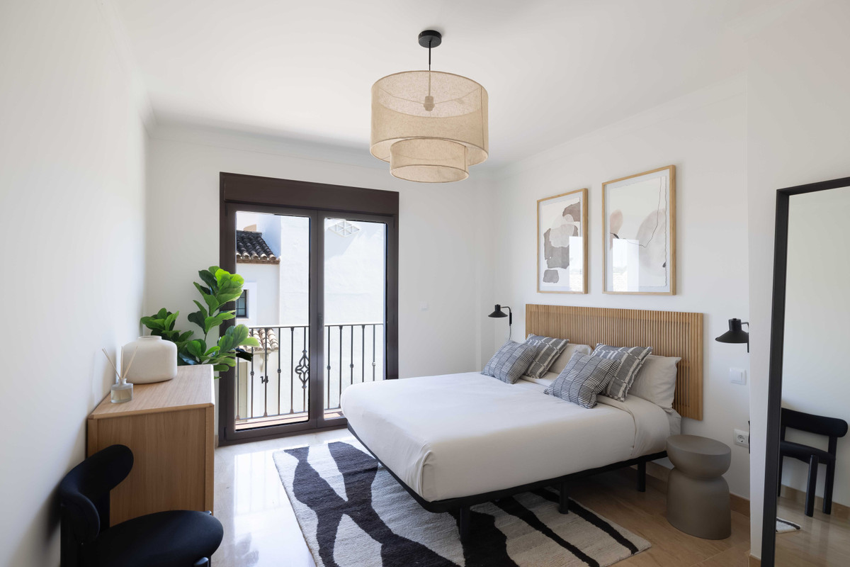Altoasis – Valle Romano - bright modern bedroom with rattan headboard, balcony, and natural wood furnishings