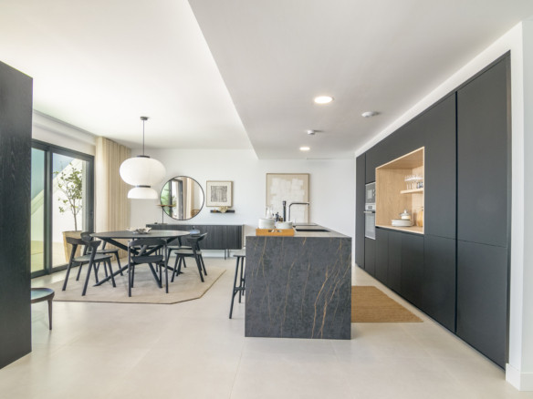Lomas 2 – Fuengirola - open-plan kitchen and dining area with dark marble island and matte black cabinetry