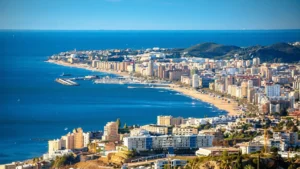 Aerial coastal view of Fuengirola: the seafront, marina, long beach and mountains behind, Costa del Sol