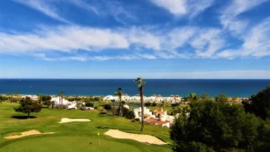 A golf course green and fairway with the sea in the background on the Costa del Sol