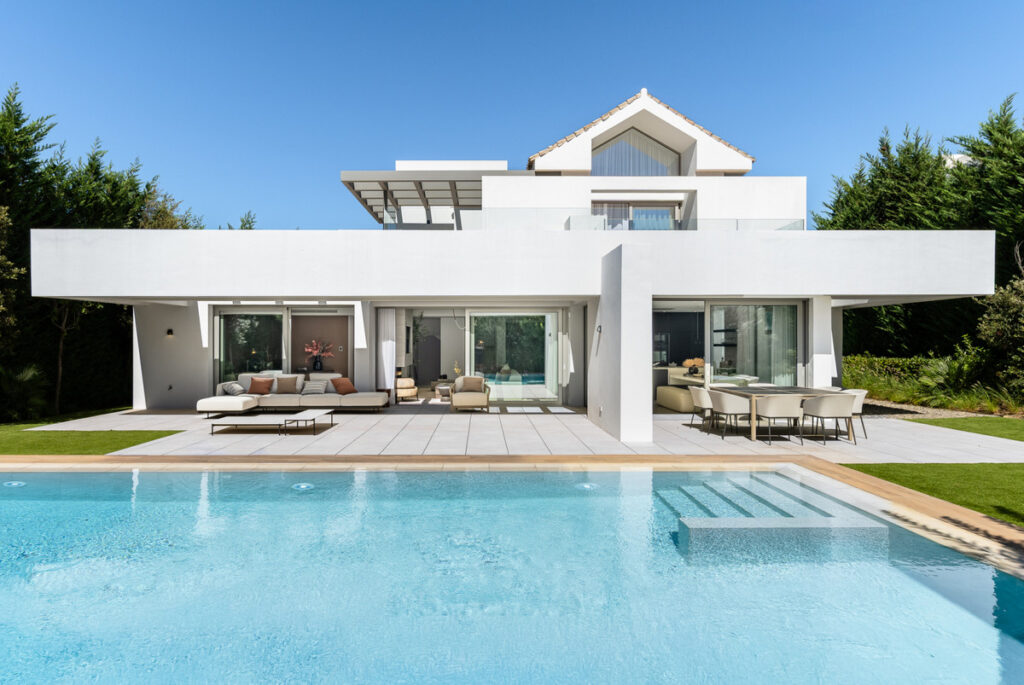 Nine in Paradise – Estepona - modern white villa exterior with large swimming pool, covered terrace, and outdoor lounge and dining areas